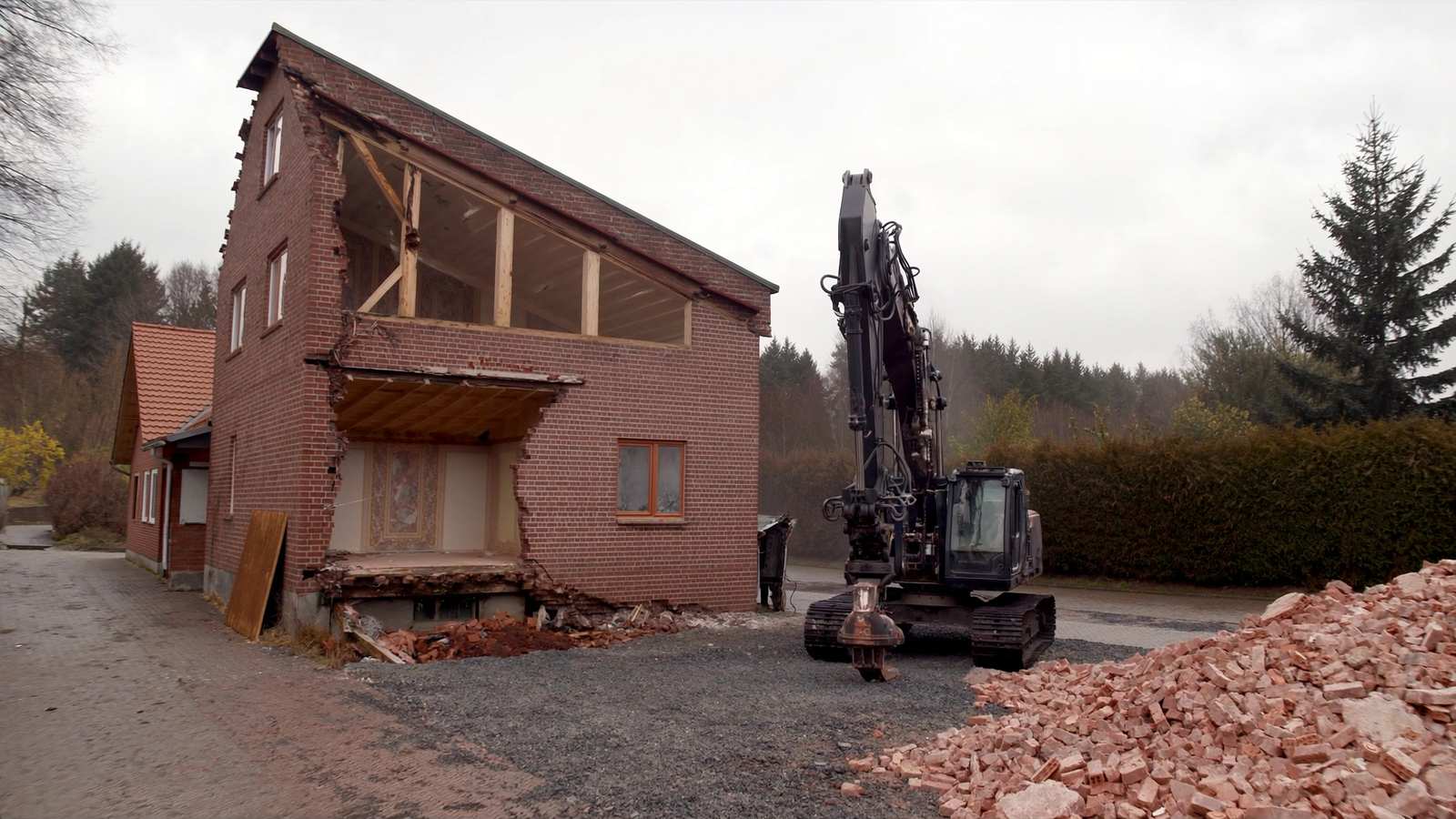 Kettenbagger beim Teilabbruch eines Backsteinhauses